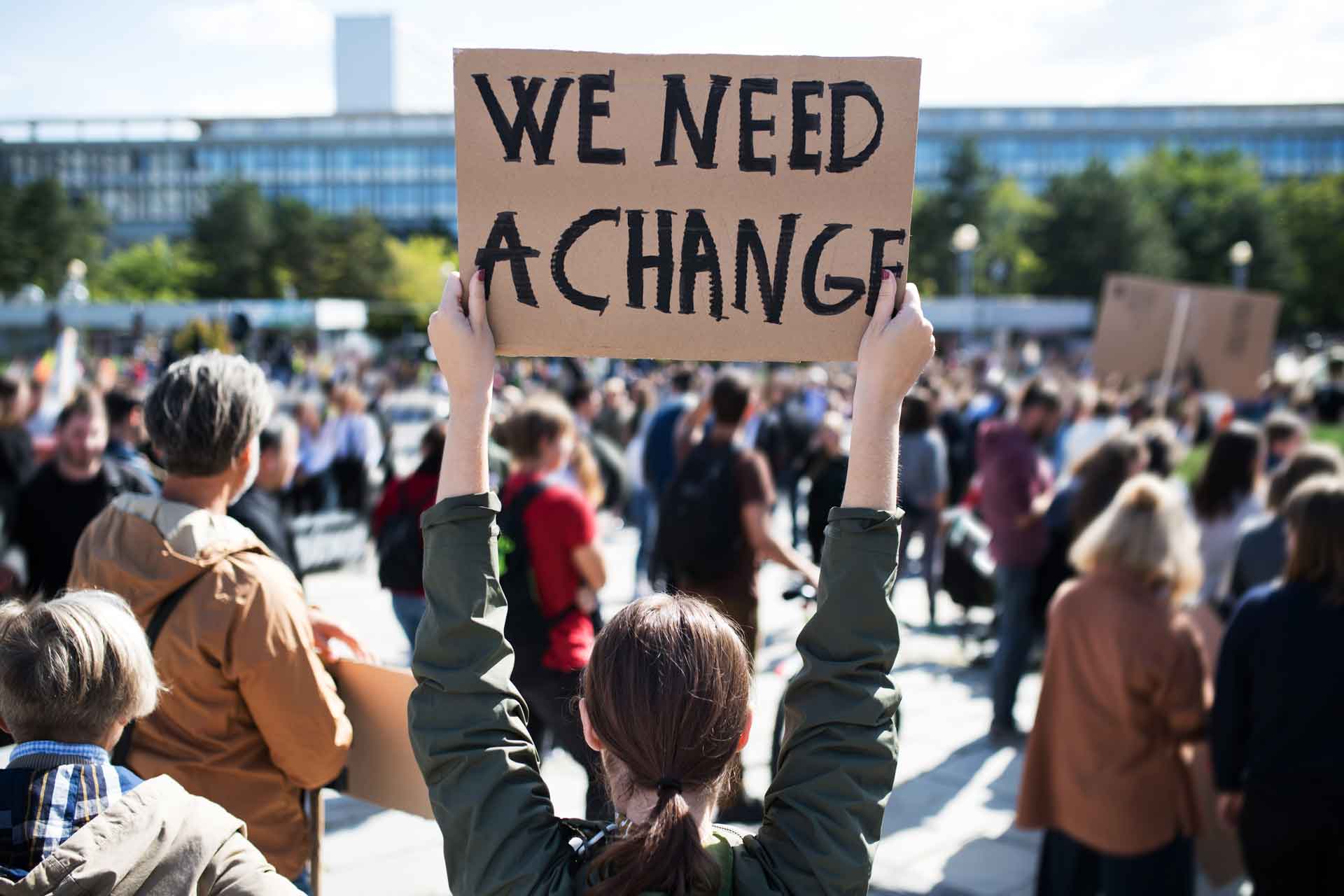 Rear view of people with placards and posters on global strike for climate change. Gemeinschaft als Denkmodell: Zur Aktualität utopischer Entwürfe in Zeiten gesellschaftlicher Transformation
